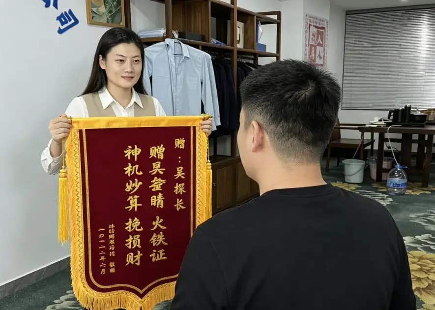 客户亲送锦旗,背景为深圳名探真实办公场地